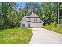 Charming two-story home with attached garage, long drive, and surrounded by mature trees at 2612 Cold Springs Rd, Concord, NC 28025