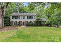 Charming two-story home with traditional architecture, mature trees, and a well-maintained lawn at 2917 Rustic Ln, Charlotte, NC 28210