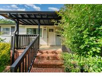 Inviting front entrance with brick steps, dark railing, and a covered porch area at 307 Elm St, Belmont, NC 28012