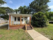 Charming single-story home featuring a cozy front porch, brick foundation and freshly landscaped yard at 322 Buffalo St, Shelby, NC 28150
