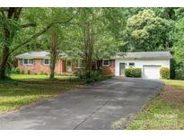 Charming brick ranch home with mature trees and a long driveway leading to a one car garage at 3230 Kingsfield Rd, Rock Hill, SC 29732