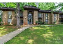 Charming brick condo building with well-maintained landscaping and a welcoming entrance at 338 Orchard Trace Ln # 8, Charlotte, NC 28213