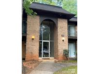 Attractive brick condo building with a unique archway entrance and exterior lights at 338 Orchard Trace Ln # 8, Charlotte, NC 28213
