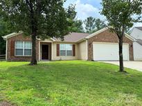 Charming brick and vinyl home with a well-maintained lawn and two-car garage at 7267 Sandown Ct, Harrisburg, NC 28075