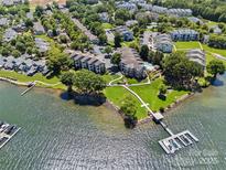Stunning aerial view of waterfront condos featuring a private dock, boat slip, and tranquil lake access at 7845 Village Harbor Dr, Cornelius, NC 28031