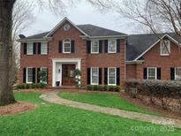 Charming two-story brick home with black shutters and a beautifully landscaped front yard at 905 Mangionne Dr, Matthews, NC 28105