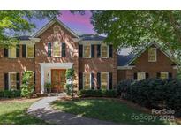 Charming two-story brick home boasts a manicured lawn, symmetrical design, and a welcoming entryway at 905 Mangionne Dr, Matthews, NC 28105