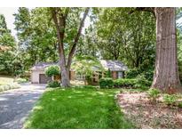 Charming single-story home with brick accents, lush lawn, and mature trees providing ample shade at 928 Tally Ho Ct, Charlotte, NC 28212
