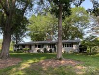 Charming one-story home featuring a well-manicured front lawn and mature shade trees at 103 Boyd Dr, Stanley, NC 28164