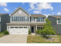 Charming two-story home with blue shutters, a white garage door, and a well-manicured front yard at 1311 Rowan Ln, Monroe, NC 28110
