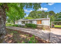 Charming single story home with a ramp and covered parking, surrounded by mature trees and lush landscaping at 1532 Buffalo Shoals Rd, Claremont, NC 28610