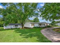 Charming single-Gathering home with a large, lush front yard and detached garage surrounded by mature trees at 1532 Buffalo Shoals Rd, Claremont, NC 28610