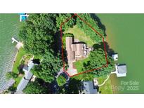 Aerial view of the lake house, including the house and the surrounding trees and lake at 160 Quail Hollow Dr, Kings Mountain, NC 28086
