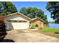 Charming lakeside home with an attached garage and a quaint wooden deck overlooking the water at 160 Quail Hollow Dr, Kings Mountain, NC 28086