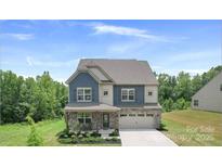 Inviting two-story home featuring a stone facade, blue accents, and a well-manicured front yard at 2009 Trindle Vine Ln, Waxhaw, NC 28173
