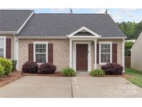 Charming brick townhome with a well-manicured front yard and a cozy covered entry at 2045 Pin Oak Pl, Cramerton, NC 28032