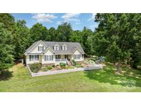 Charming yellow home featuring a manicured lawn and a classic white picket fence at 2159 Quiet Cove Ln, Stanfield, NC 28163