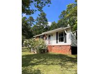 Charming single-story home with brick foundation and white siding, surrounded by lush greenery at 418 Cedar Grove Rd, Clover, SC 29710