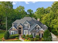 Stunning two-story home featuring stone accents, lush landscaping, and a well-manicured lawn at 4218 Ash Hollow Ln, Denver, NC 28037