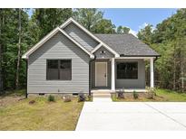 Charming single-story home featuring gray siding, black window trim and concrete driveway at 446 Mint St, Rock Hill, SC 29730