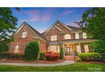 Beautiful brick two-story home with manicured lawn and mature landscaping creates amazing curb appeal at 5916 Four Wood Dr, Matthews, NC 28104