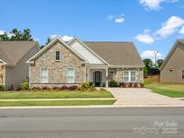 Charming stone and siding home with a manicured lawn and inviting curb appeal at 6020 Waldorf Ave, Monroe, NC 28110