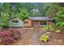 Charming home with colorful facade, landscaped front yard, and stone walkway leading to the front door at 617 Pinecrest St, Davidson, NC 28036