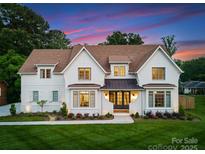 Stunning two-story white brick home with a manicured lawn and beautiful landscaping at 6505 Folger Dr, Charlotte, NC 28270
