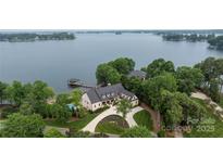 Stunning aerial view of lakefront home, boasting a private dock, pool and meticulously landscaped grounds at 8170 Bay Pointe Dr, Denver, NC 28037