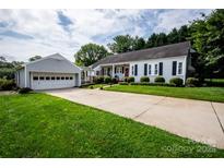 Charming single-story home with a well-manicured lawn, long driveway, and a detached two-car garage at 899 Wendover Rd # 29, Statesville, NC 28677