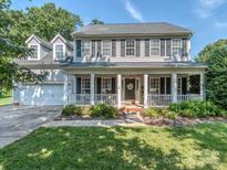 Charming two-story home featuring a welcoming front porch with white columns and manicured landscaping at 9422 Olivia Ln, Charlotte, NC 28277