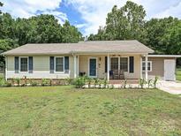 Charming single-story home with a well-maintained lawn, blue shutters, and a welcoming front porch seating area at 12423 Softwood Ct, Charlotte, NC 28273