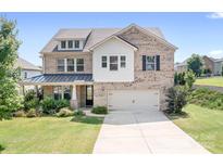 Charming brick two-story home with a well-manicured lawn and attached two-car garage at 16324 Loch Raven Rd, Huntersville, NC 28078