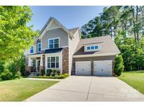 Beautiful two-story home with stone accents, manicured lawn, and an attached two-car garage at 2205 Gallberry Ln, Waxhaw, NC 28173