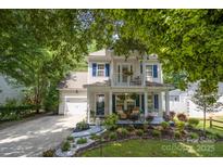 Charming two-story home featuring a welcoming front porch, upper balcony, attached garage and beautifully landscaped yard at 4439 Brandie Glen Rd, Charlotte, NC 28269