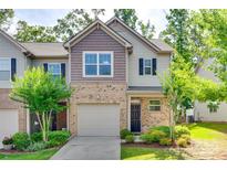 Charming townhome exterior with brick accents, attached garage, and manicured lawn at 5033 Mockernut Ln, Indian Land, SC 29707