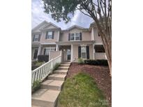 Traditional townhome with neutral siding, dark shutters, and a white picket fence leading to the front door at 6307 Rhodins Ln, Fort Mill, SC 29707