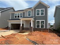 New two-story home boasts a gray exterior, white trim, brick accents, and an attached two-car garage at 634 Amberjack Pl # 77, York, SC 29745