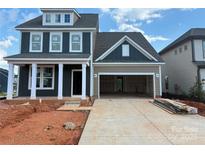 Two-story home with a gray exterior and a spacious two-car garage in a construction zone at 646 Amberjack Pl # 74, York, SC 29745