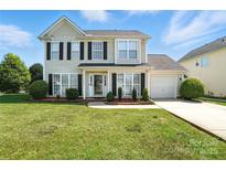 Charming two-story home featuring black shutters, a manicured lawn, and a single-car garage at 7442 Sparkleberry Dr, Indian Trail, NC 28079