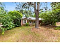 Charming single-story brick home with mature trees and a cozy front porch at 7501 Glencannon Dr, Charlotte, NC 28227