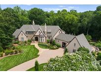 Expansive estate home with beautiful landscaping, stone accents, and a circular driveway, perfect for luxurious living at 8500 Longview Club Dr, Waxhaw, NC 28173
