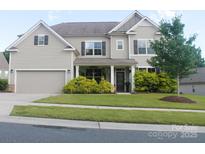 Charming two-story home with a well-maintained lawn and inviting front porch at 858 Oak Manor Se Dr, Concord, NC 28025