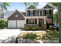 Charming two-story home with a welcoming front porch, manicured lawn, and a two car garage at 9412 Rosalyn Glen Rd, Cornelius, NC 28031