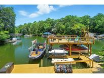 Picturesque waterfront view featuring a private boat dock with boat lifts and a lounging area at 10043 Tepa Pl, Tega Cay, SC 29708