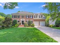 Beautiful brick two-story home with manicured lawn and mature trees at 10127 Tallent Ln, Huntersville, NC 28078