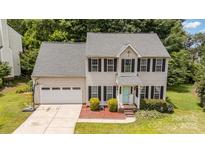 Charming two-story home features a well-maintained lawn, attached garage, and a welcoming front entrance with bright blue door at 108 Shade Tree Cir, Fort Mill, SC 29715
