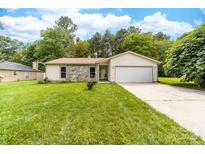 Charming single-story home features a stone facade, attached garage and a well-manicured lawn at 10951 Fox Mill Ln, Charlotte, NC 28277