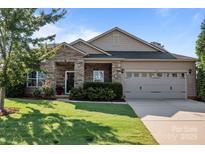 Charming single-Gathering home featuring a stone facade, well-manicured lawn, and a two-car garage at 112 E Neel Ranch Rd, Mooresville, NC 28115