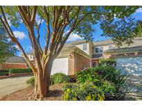 Charming townhouse with brick facade, white garage door, manicured flower garden and mature crape myrtle at 11234 Villa Trace Pl, Charlotte, NC 28277